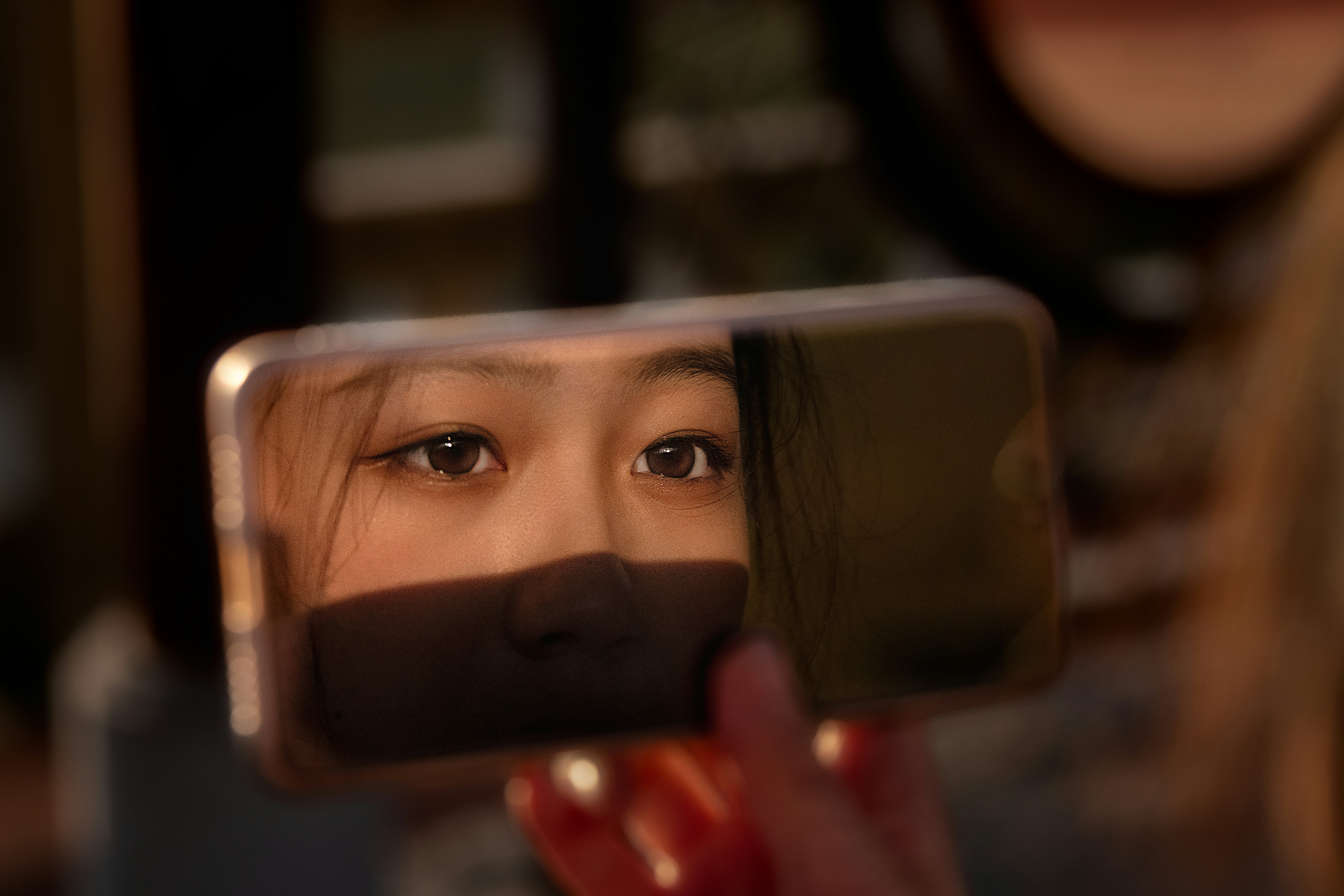 스마트폰 화면에 흐릿한 피해 이미지가 보이는 클로즈업. 디지털 성범죄의 개인적 고통을 상징합니다.